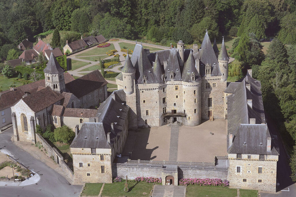 Château de Jumilhac met zijn unieke alchemistische symbolen en indrukwekkende Renaissance torens, omgeven door weelderige tuinen.