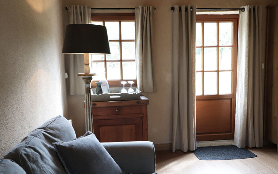 Luxe Vakantiehuis Dordogne - Interieur met uitzicht Gezellig interieur van luxe vakantiehuis in Dordogne met grote ramen en natuurlijke lichtinval.