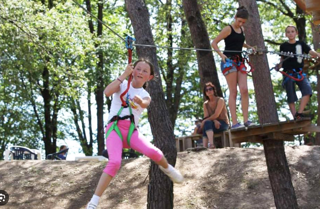 Bezoekers genieten van de boomtopparcours en andere activiteiten in Accroparc de Soyaux, een ideale locatie voor een actief uitje met vrienden en familie.