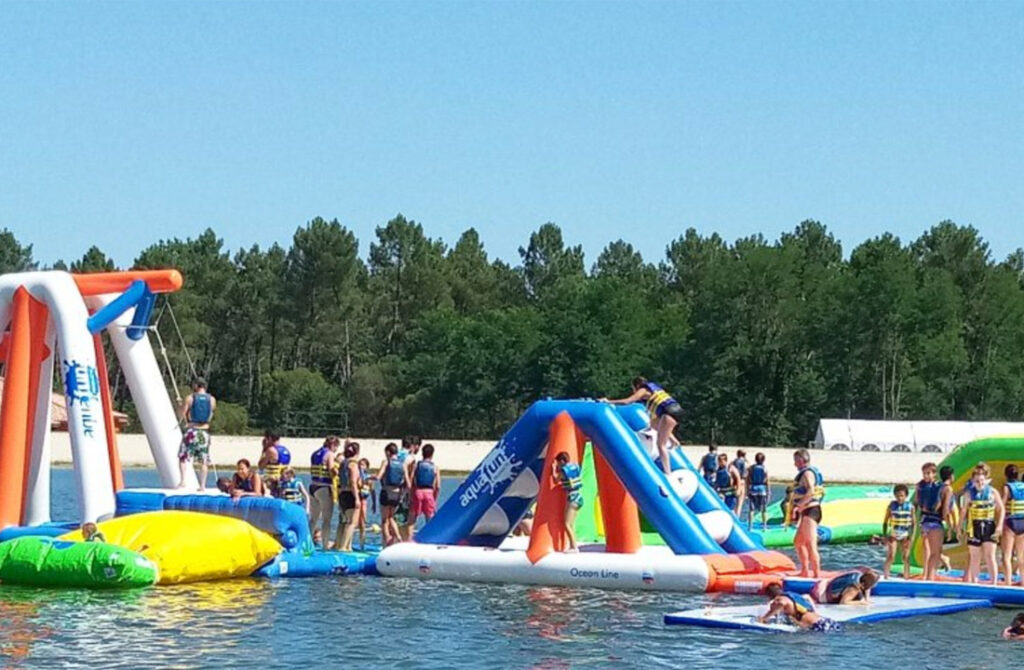 AquaFun Park de Casteljaloux met opblaasbare waterattracties en glijbanen, ideaal voor een dag vol plezier aan het meer.