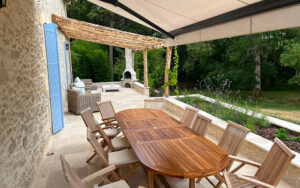 Uitzicht op tuin en buitenkeuken van luxe vakantiehuis in Dordogne.