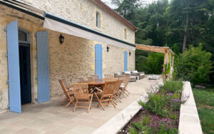 Uitzicht op terras met houten tafel en tuin in Dordogne.