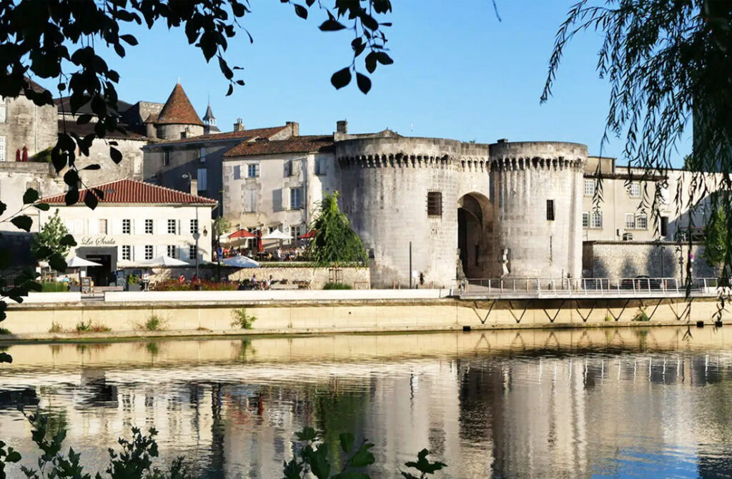 Pittoreske straat in Cognac met vakwerkhuizen en uitzicht op het Kasteel van Cognac, omringd door de prachtige natuur van de Charente.