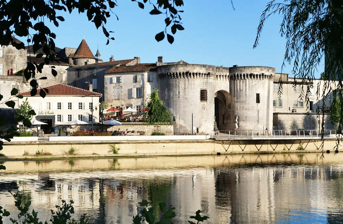 Pittoreske straat in Cognac met vakwerkhuizen en uitzicht op het Kasteel van Cognac, omringd door de prachtige natuur van de Charente.