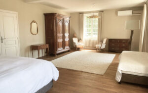 Luxe Vakantiehuis Dordogne Ruime slaapkamer in luxe vakantiehuis in Dordogne met elegant meubilair en grote ramen.