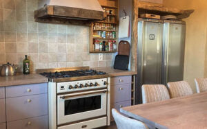Cozy Dordogne Kitchen with Rustic Charm Charming kitchen in Domaine du Tilleu with vintage stove, wooden accents, and modern appliances. Per.