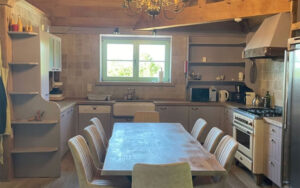 Charming Dordogne Holiday Home Kitchen Cozy kitchen in Domaine du Tilleu with rustic wooden beams and modern amenities. Perfect for relaxin.