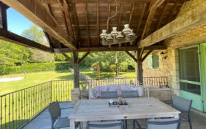 Cozy outdoor dining area at Domaine du Tilleu Outdoor dining space with wooden table and chairs at Domaine du Tilleu, Dordogne. Perfect for relaxi.