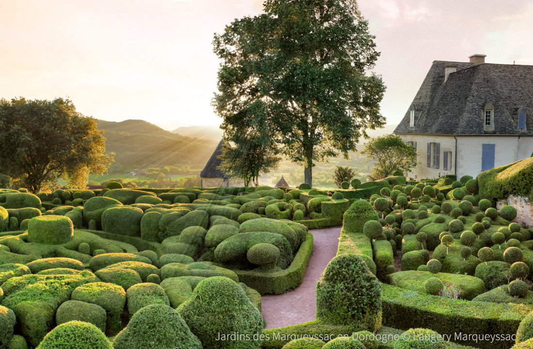 Schilderachtige wandelpaden tussen buxusboompjes in de Tuinen van Marqueyssac, met panoramisch uitzicht op de Dordogne-vallei en kastelen.