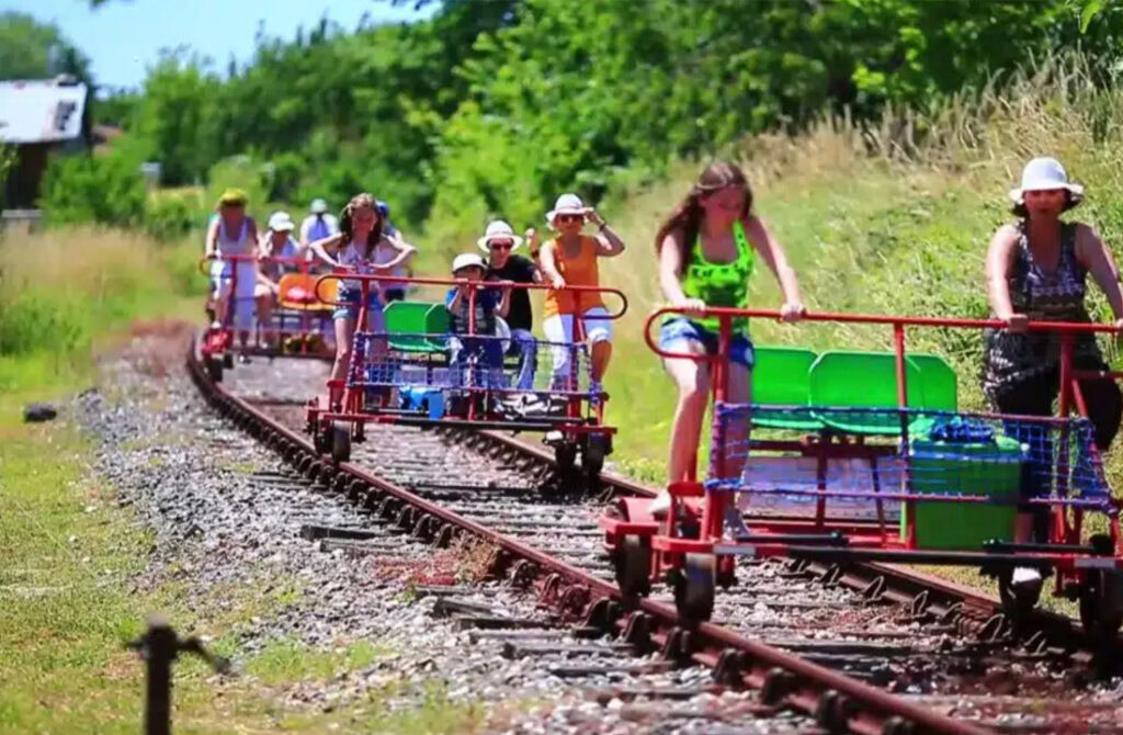 Gezinnen die op de Vélorail fietsen over oude spoorlijnen, omringd door het rustige Franse platteland.