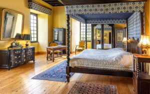 Elegant bedroom with four-poster bed and vintage furniture in Dordogne.