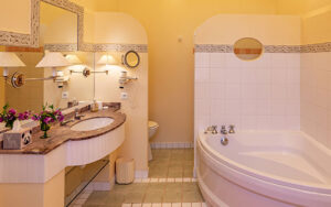 Elegant bathroom featuring a large bathtub, warm lighting, and classic decor for a relaxing stay.