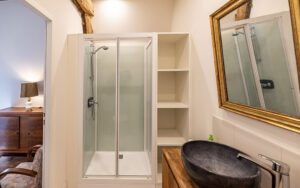 Modern bathroom with shower and rustic decor in Dordogne vacation rental.