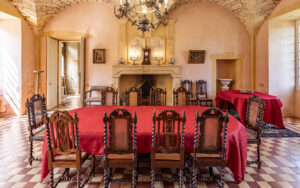 Elegant dining room with antique furniture and a grand fireplace in a Dordogne holiday home.