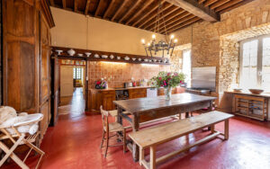 Cozy rustic dining room with wooden furniture and exposed brick walls in Dordogne.
