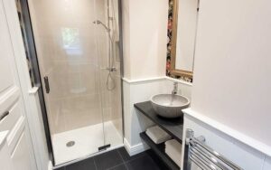 Ruime badkamer in luxe vakantiehuis in Dordogne met moderne inloopdouche en stijlvolle wastafel. Per.