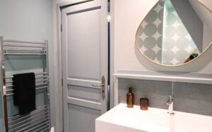 Moderne badkamer met wastafel, spiegel en handdoekradiator in luxe vakantiehuis Dordogne.