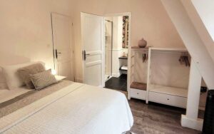 Ruime slaapkamer in luxe vakantiehuis in Dordogne met comfortabele bed en gezellige inrichting.