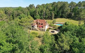 Luxe vakantiehuis in Dordogne met zwembad, omgeven door groen bos en natuur.