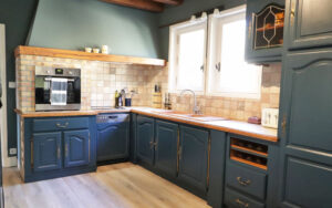Elegant kitchen with blue cabinets, wooden accents, and modern appliances in a luxury Dordogne vacation home.