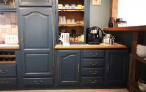 Cozy Dordogne vacation rental kitchen with blue cabinetry and modern appliances.