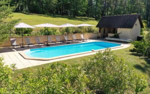 Luxe vakantiehuis met privézwembad en ligbedden in groene omgeving Dordogne.
