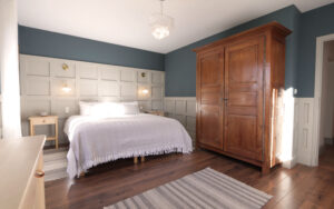 Charming bedroom with elegant decor, wooden wardrobe, and cozy ambiance in Dordogne.
