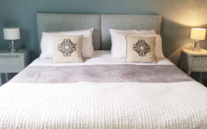 Beautiful bedroom with plush bedding, decorative pillows, and elegant bedside lamps in Dordogne.