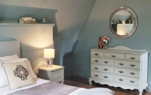 Elegant bedroom with vintage dresser and cozy ambiance in Dordogne countryside.
