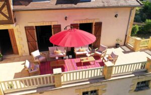 Luxe vakantiehuis in Dordogne met terras, tuinmeubels en grote parasol.