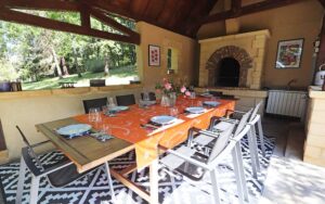 Gezellige eettafel in luxe vakantiehuis Dordogne met uitzicht op tuin.