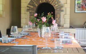 Elegante dinertafel met bloemen en glazen in luxe vakantiehuis Dordogne.
