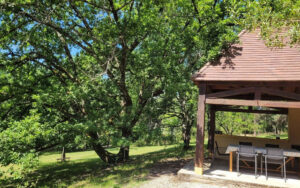 Beautiful outdoor dining area with lush greenery in Dordogne, ideal for relaxation.
