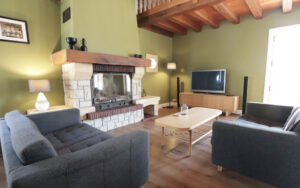 Cozy living room with fireplace in a luxury Dordogne vacation house.