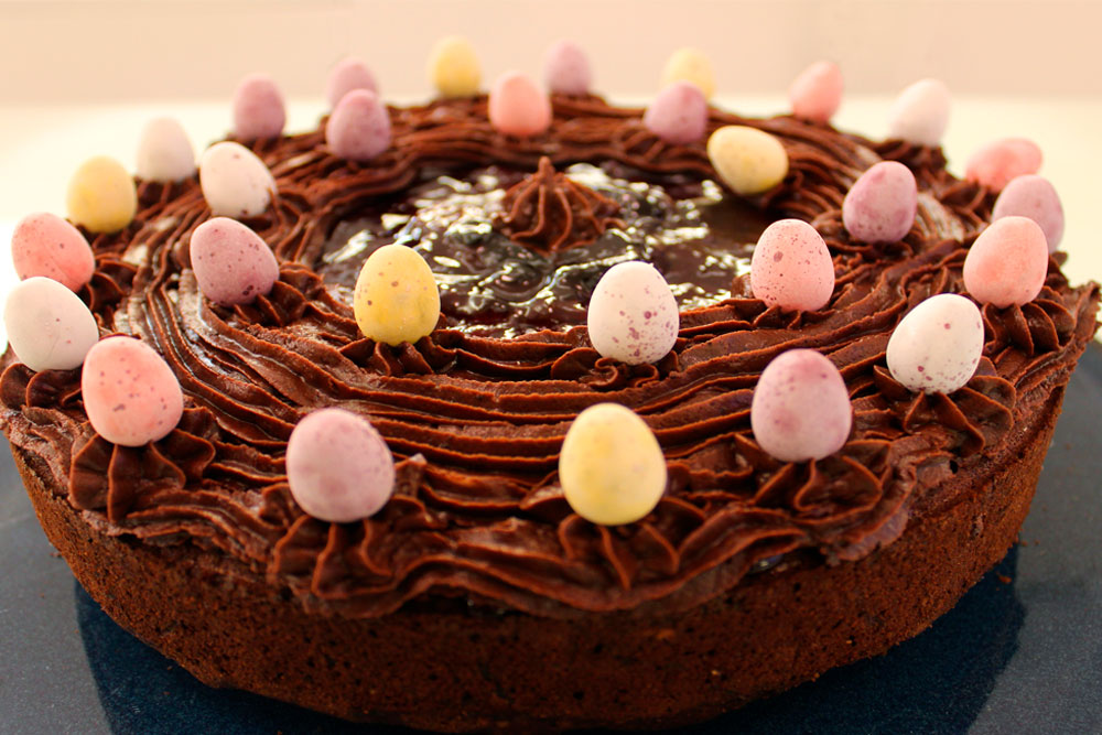 Easter chocolate cake decorated with pastel candy eggs and chocolate shavings.