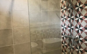 Ruime inloopdouche met moderne regendouche en geometrische tegelaccenten in luxe vakantiehuis Dordog.