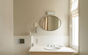Moderne badkamer in luxe vakantiehuis met spiegel en raam.
