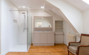 Moderne badkamer in luxe vakantiehuis met inloopdouche en houten vloer.