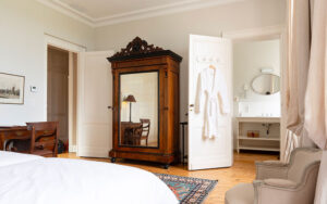 Elegant interieur van een luxe vakantiehuis in Dordogne met antieke kast en comfortabele stoel.