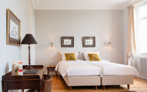 Luxe slaapkamer in Dordogne vakantiehuis met tweepersoonsbed en kunstwerken.