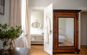 Elegant slaapkamer met grote spiegel en antieke kast in Dordogne.