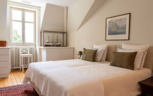 Luxe slaapkamer in Dordogne met wit beddengoed en kunst aan de muur.
