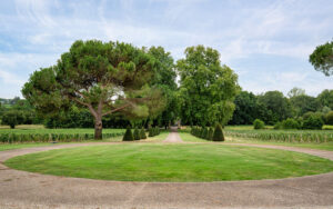 Uitgestrekte tuin met grote bomen en een pad in Dordogne.