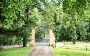 Elegante metalen poort met natuur rondom, toegang tot Château de Bel Air.