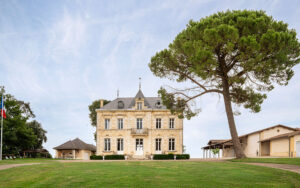 Historisch kasteel in Dordogne met grote boom en groene tuin.