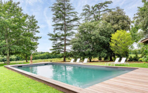 Luxe vakantiehuis met zwembad en omringende groene tuin.