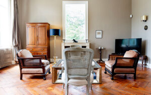 Luxe woonkamer in Dordogne vakantiehuis met klassieke meubels en grote ramen.