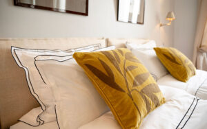 Luxe slaapkamer met gele kussens en wit beddengoed in Dordogne.