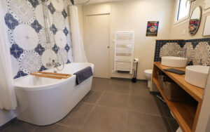 Luxe badkamer met vrijstaand bad en dubbele wastafel in Dordogne vakantiehuis.