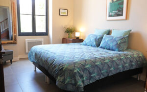 Moderne slaapkamer in luxe vakantiehuis met grote ramen en decoratieve posters.